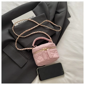 Detail showing pink quilted mini box bag with chain strap and phone for size reference