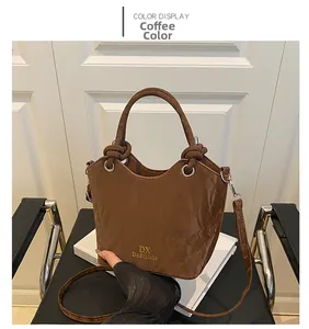 Détail du sac seau marron café avec texture froissée et logo DX doré élégant