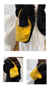 Détail d'un sac seau jaune vif avec une texture mate et une bandoulière nouée décorative