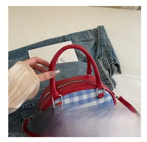 Detail of red and blue plaid crossbody bag with comfortable leather handle and zip closure
