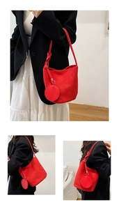 Détail du sac seau rouge mat avec bandoulière tressée unique et pochette assortie