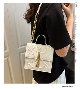 Detail of white 3D leaf textured handbag with golden metal chain and clasp lock