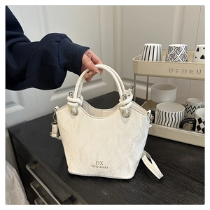 Détail du sac seau blanc avec texture plissée unique et poignée en corde épaisse
