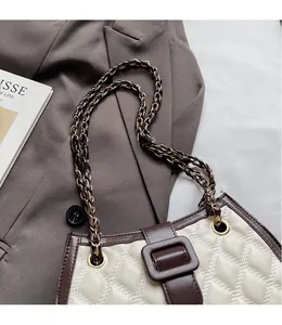 Dettagli di cuciture trapuntate e tracolla a catena su borsa a tracolla beige vintage