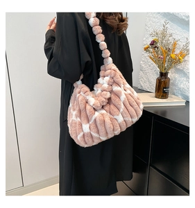 Detail of pink and white plush shoulder bag with decorative furry strap balls