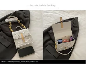 Detail view of white pleated leather bag with gold lock and chain strap showing internal space