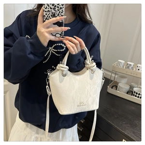 Détail du sac seau blanc texture marbre avec logo doré et poignée en corde