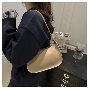 Close-up of beige PU leather hobo shoulder bag worn by model in a casual setting