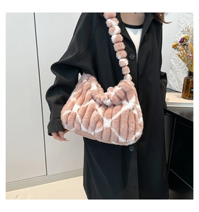 Detailed view of pink striped plush tote bag with fuzzy pom-pom shoulder strap