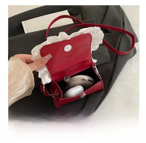 Interior view showing capacity for lipstick and earbuds in a red lace bow square bag