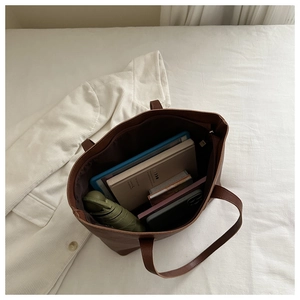 Détail du grand sac cabas marron foncé montrant l'espace intérieur et la poche zippée