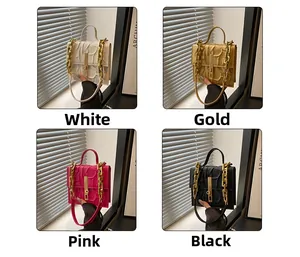 Detail of elegant handbags in white, gold, pink and black with textured relief and gold chains