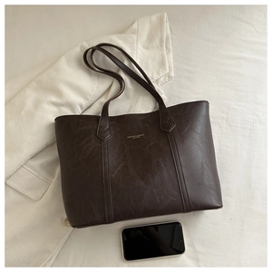 Détail du sac cabas marron foncé avec texture cuir naturel et lettrage doré gaufré