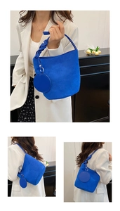 Détail du sac seau bleu Klein avec poignée tressée et breloque porte-monnaie ronde