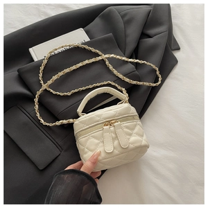 Detail of quilted leather mini bag with gold chain strap and dual zipper closure