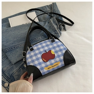 Detail of blue and white checkered bag with apple print and detachable black strap