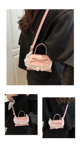 Detail of pink ballet-style bag featuring white lace trim and a leather bow decoration