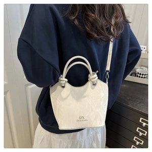 Détail du sac bandoulière en similicuir marbré avec poignée à nœud créative