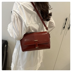 Vue détaillée du sac bandoulière bordeaux avec pendentif cœur doré et finition brillante