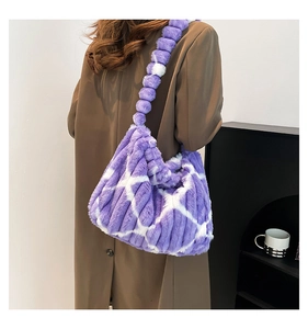 Detail of purple faux fur tote bag featuring white grid pattern and plush pom-pom strap