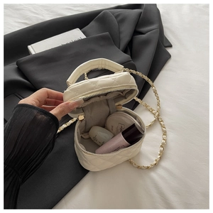 Macro detail of quilted mini box bag showing grey herringbone lining and interior capacity