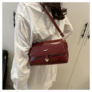 Détail du sac à bandoulière vintage rouge foncé avec verrou coeur doré et sangle réglable