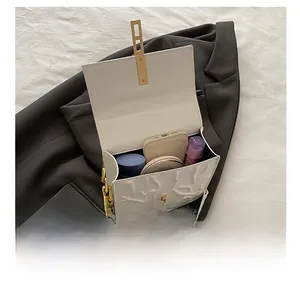 Detail view of the relief pattern crossbody bag showing internal storage capacity