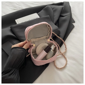 Interior view of pink quilted mini box bag with cosmetics and golden chain strap