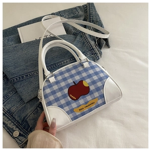 Close-up of blue and white checkered bag with fruit illustrations and leather handles