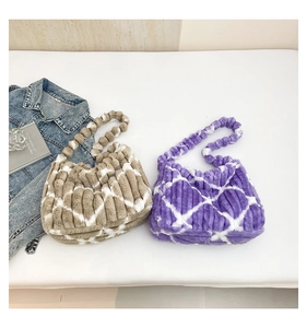 Detail of plush tote bag with quilted pattern and unique spherical bead handles