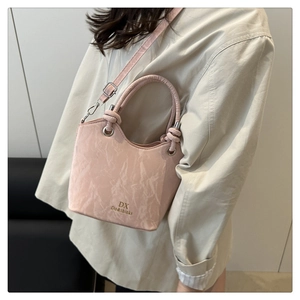 Sac seau rose élégant porté en bandoulière avec texture marbrée et poignée à nœud épaisse
