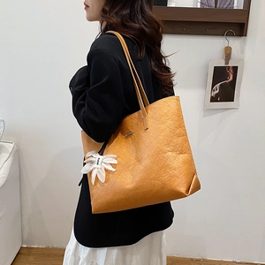 Retro mustard yellow oversized tote bag with pleated texture and floral pendant detail