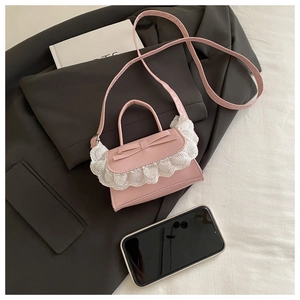 Close-up of pink ballet-style bag with lace trim and bow on a grey blazer ootd