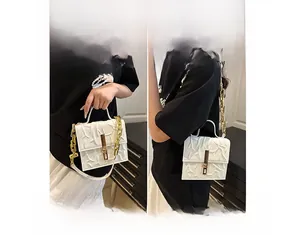 Detail view of white PU bag with unique branch texture and gold metal buckle accents