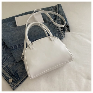 Detail of white semi-circular PU leather handbag with silver hardware and smooth finish