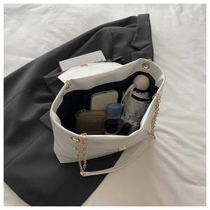 Detail of white large capacity tote bag with gold chain and spacious interior for daily use