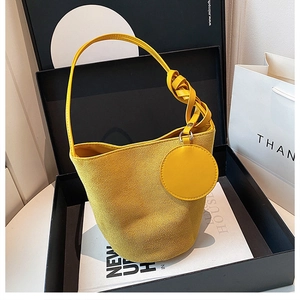 Sac seau en daim jaune gingembre avec bandoulière nouée dans un coffret cadeau noir