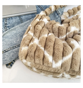 Detail of plush striped tote bag featuring soft faux fur texture and bubble handle