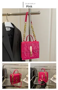 Detail of rose pink square bag featuring 3D embossed texture and gold chain strap