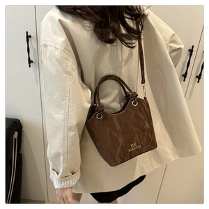Détail du sac seau marron en cuir PU plissé avec logo de la marque et œillet métallique