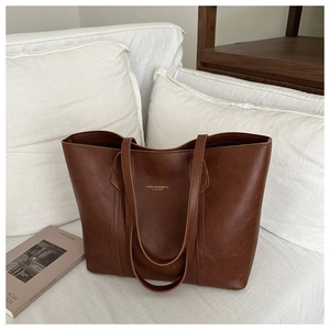 Sac fourre-tout marron rétro de grande capacité posé sur un canapé en tissu blanc