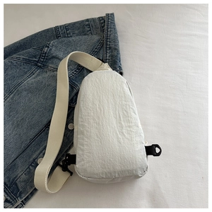 Detail of waterproof nylon chest bag with adjustable black buckle on denim background