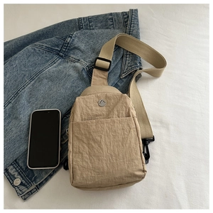 Waterproof nylon crossbody chest bag in khaki shown with mobile phone for scale