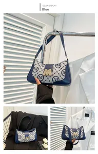 Close-up of vintage monogram shoulder bag featuring blue M letter buckle and fabric texture