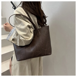 Détail du cabas marron foncé avec texture mate vintage et surpiqûres verticales sur le sac
