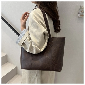 Gros plan sur un sac cabas vintage marron foncé avec texture en simili cuir vieilli