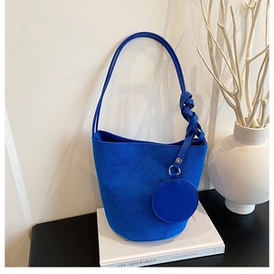 Détail du sac seau bleu en faux daim avec sangle nouée et porte-monnaie rond assorti