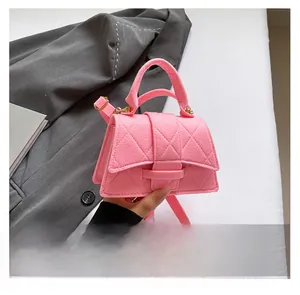 Detail of pink quilted PU leather handbag with gold clasp and top handle