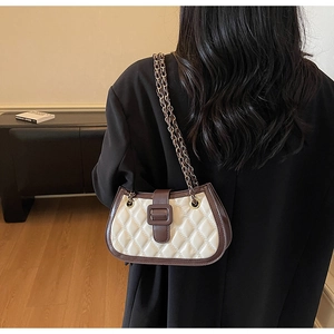 Chic quilted half-moon bag featuring creamy leather, brown trim, and metal chain strap