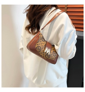 Close-up of a vintage monogram shoulder bag with gold metal buckle on a female model